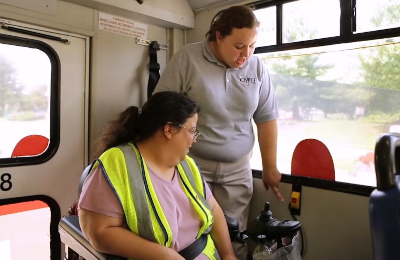 CMRT travel trainer on bus with rider in wheelchair.