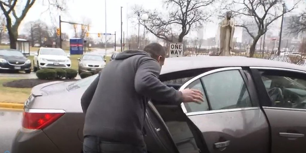 Person in winter coat gets into the rear seat of a Lyft on a winter day
