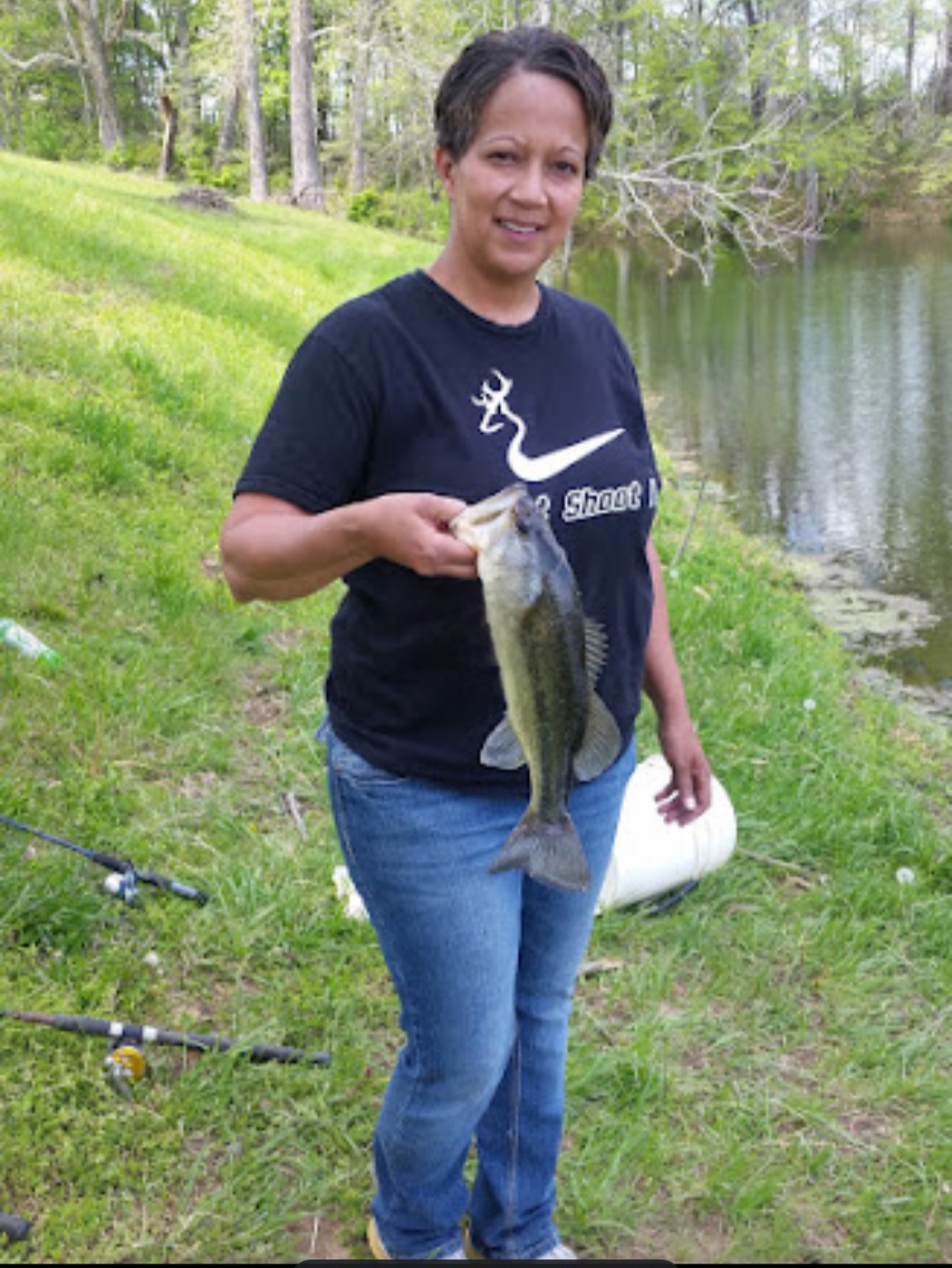 woman holding a fish by a lake